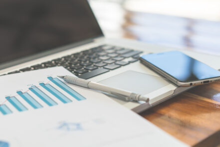 Financial charts on the table with laptop ( Filtered image processed vintage effect. )