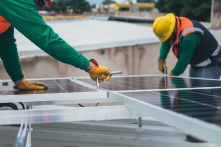 Workers fixing solar panels