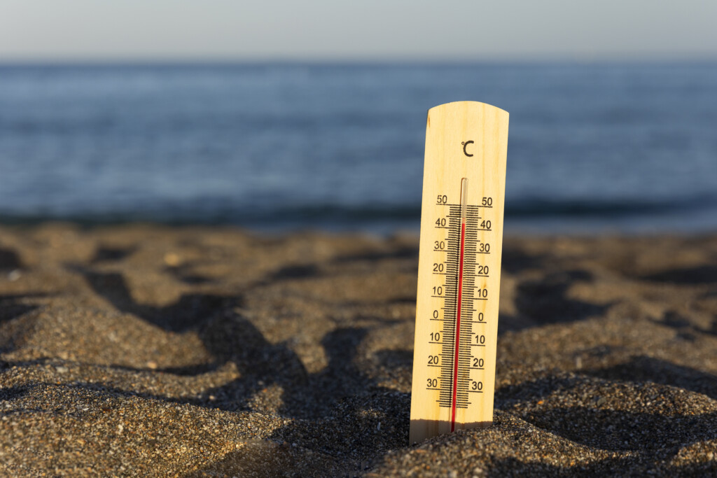 extremely hot temperature showing on thermometer on the beach