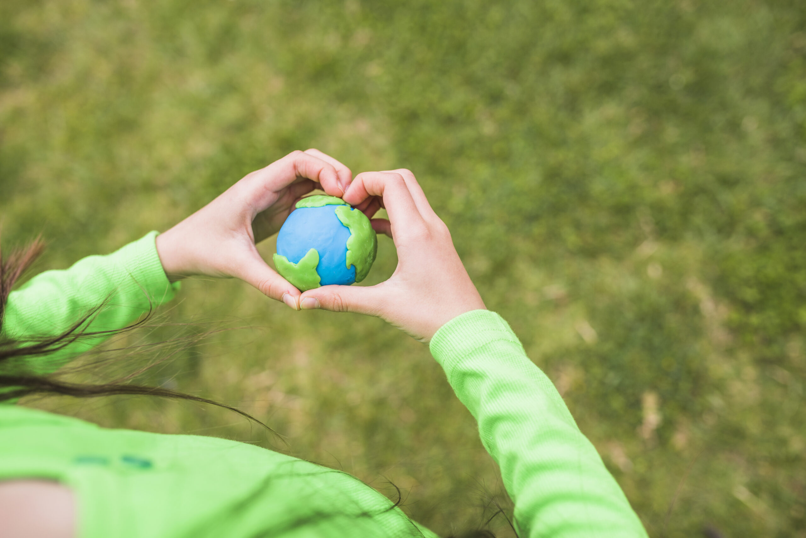 A woman holding a plasticine planet representing love for the planet also meaning the title of our articleEnvironmental Health and Safety Standards: A Global Perspective ,