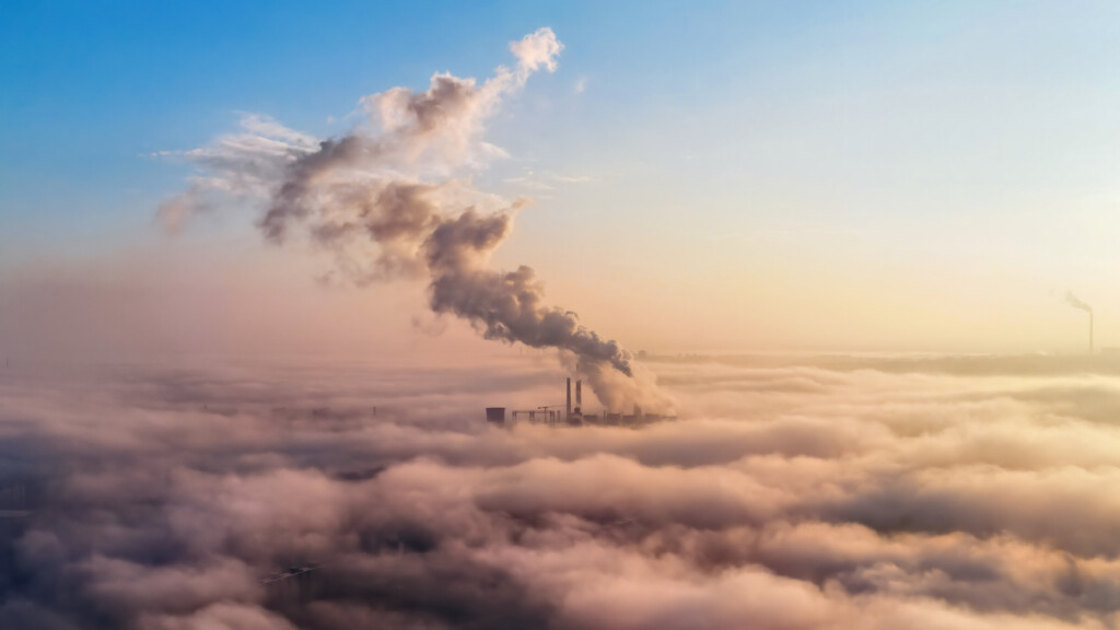 View of a thermal station in the distance above the clouds, columns of smoke, ecology idea